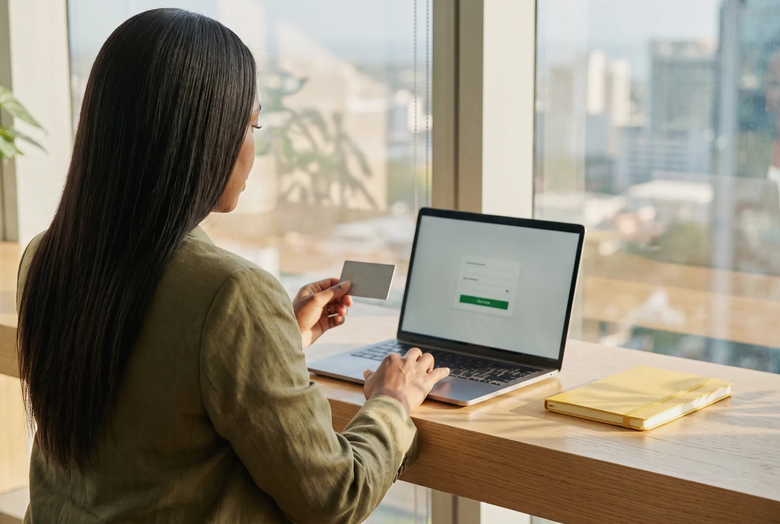 Woman paying for an online order by card on her laptop